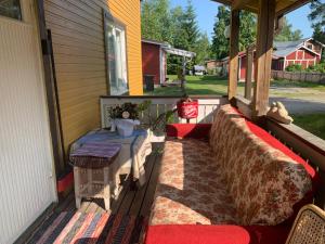 een veranda met 2 stoelen met kussens en een tafel bij Grandma’s house in Iisalmi