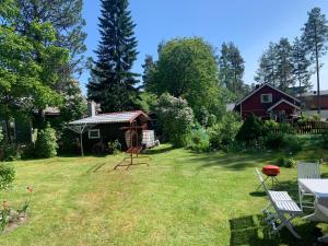 um quintal com uma casa, uma mesa e cadeiras em Grandma’s house em Iisalmi