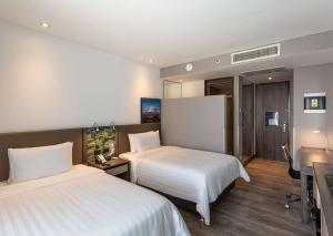 a hotel room with two beds and a desk at Hampton by Hilton Arequipa in Arequipa