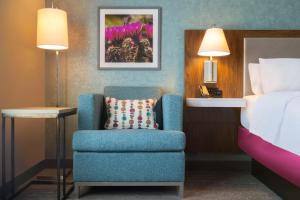ein Schlafzimmer mit einem blauen Stuhl und einem Bett in der Unterkunft Hampton Inn Clovis, Nm in Clovis