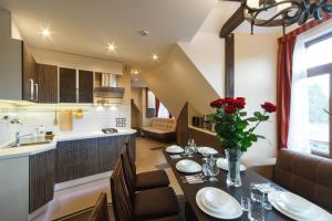 a kitchen and dining room with a table with red roses at StoneBridgeLuxApart Free Parking in Rīga