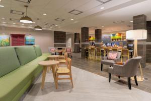 a waiting area with tables and chairs in a restaurant at Home2 Suites By Hilton Alcoa Knoxville Airport in Alcoa