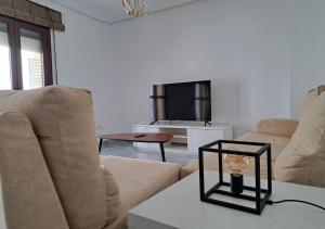 a living room with two couches and a tv at Encanto Urbano: Piso céntrico totalmente equipado in Lebrija