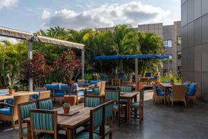 a restaurant with tables and chairs and palm trees at Radisson Blu Hotel Lusaka in Lusaka