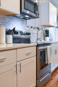 cocina con armarios blancos y fogones en Beautiful Irving two bedroom apartment, en Filadelfia