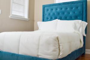 Beautiful Irving two bedroom apartment في فيلادلفيا: سرير مع اللوح الأمامي الأزرق والوسائد البيضاء