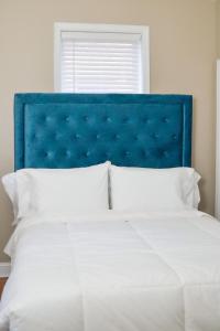 Beautiful Irving two bedroom apartment في فيلادلفيا: سرير مع اللوح الأمامي الأزرق والوسائد البيضاء