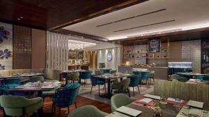 クアラルンプールにあるViiA Residence, Mid Valley KLのテーブルと椅子とバーのあるレストラン