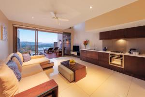 ein Wohnzimmer mit einem Sofa und einer Küche in der Unterkunft The Terraces Boutique Apartments in Port Vila