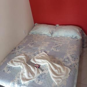 ein Bett mit zwei Kissen und Decken darauf in der Unterkunft Espaço Rústico in Macaé