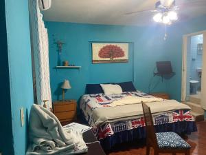 a bedroom with a bed and a blue wall at Recamara a media cuadra de la playa in Mazatlán