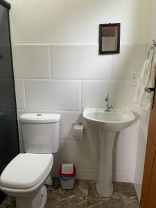 uma casa de banho branca com um WC e um lavatório em Espaço Rústico em Macaé