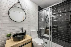 a bathroom with a sink and a toilet and a mirror at Luxe apartments Madrid Rio by RentitUP in Madrid