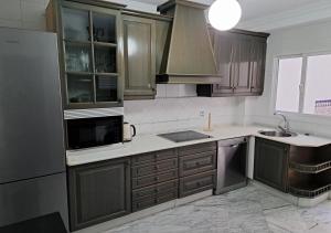 a kitchen with wooden cabinets and stainless steel appliances at Encanto Urbano: Piso céntrico totalmente equipado in Lebrija