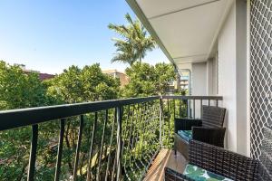 uma varanda com cadeiras e vista para as árvores em Charming 3-bed Apartment near Local Shops em Brisbane