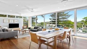 ein Wohnzimmer mit Tisch und Stühlen in der Unterkunft Beautiful Views, Secluded Beaches and Stunning Bush Walks All At Your Doorstep in Booker Bay