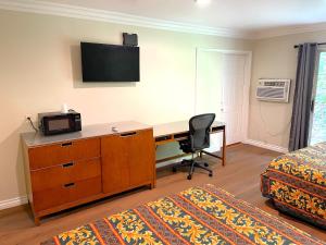 a bedroom with a desk with a computer and a bed at Relax Inn in Los Angeles