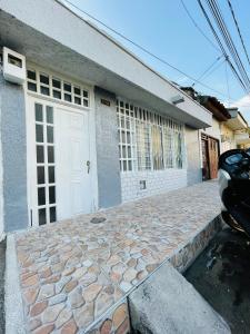a house with a white door and a stone driveway at Apartamento cerca a la Basilica Buga valle in Buga