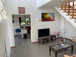 a living room with a flat screen tv and a staircase at Mango Prima in Moalboal