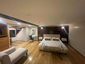 una camera con letto, scrivania e divano di Hotel Ensueños a Cuenca