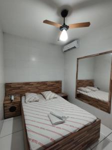 サンパウロにあるHotel novo sol santo amaroのベッドルーム1室(ベッド1台、天井ファン、鏡付)