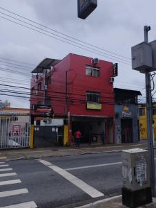 um edifício vermelho na esquina de uma rua em Hotel novo sol santo amaro em São Paulo