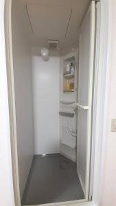 una pequeña nevera blanca en una habitación pequeña en Noah House 102貸切, en Shingu
