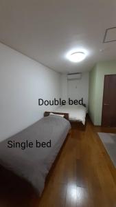 1 dormitorio con 1 cama doble y 1 cama individual en Noah House 102貸切, en Shingu