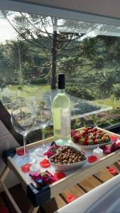 uma mesa com uma garrafa de vinho e copos de vinho em Winter Valley Cabins em São Joaquim
