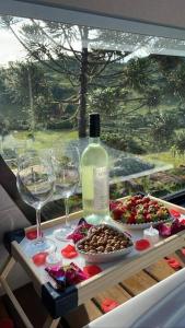 a table with a bottle of wine and wine glasses at Winter Valley Cabins in São Joaquim