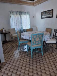 a dining room with a table and chairs and a table and chairs at Oslob Hilltop Transient House in Cañang