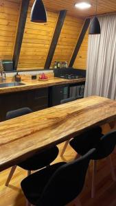 uma cozinha com uma longa mesa de madeira e cadeiras em Winter Valley Cabins em São Joaquim