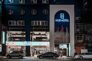 a large building with cars parked in front of it at Hub Hotel Kaohsiung Yisin Branch in Kaohsiung