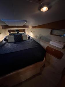 a large bed in the back of a boat at LUXURY 40 FOOT YACHT ON 5 STAR OCEAN VILLAGE MARINA SOUTHAMPTON - minutes away from city centre and cruise terminals - Free parking included in Southampton