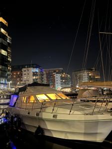 un barco sentado en el agua por la noche en LUXURY 40 FOOT YACHT ON 5 STAR OCEAN VILLAGE MARINA SOUTHAMPTON - minutes away from city centre and cruise terminals - Free parking included, en Southampton