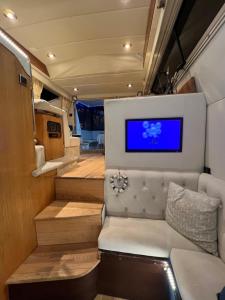 a living room with a couch and a tv on the wall at LUXURY 40 FOOT YACHT ON 5 STAR OCEAN VILLAGE MARINA SOUTHAMPTON - minutes away from city centre and cruise terminals - Free parking included in Southampton