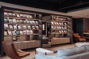 a book store with a couch and chairs and books at Hub Hotel Kaohsiung Yisin Branch in Kaohsiung
