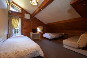 1 dormitorio con 1 cama y TV en una habitación en Lake village donaludo Pension, en Kitashiobara