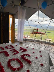 a room with red roses on a bed with a view at Juncos Glamping in Fúquene