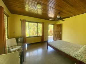 a bedroom with a bed and a wooden ceiling at La Purruja Lodge in Golfito