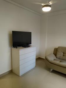 a living room with a tv and a couch at Praia Mansa Caiobá 3 quartos in Matinhos