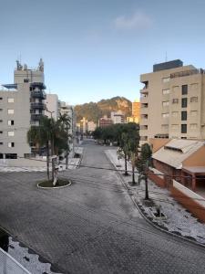 an empty street with palm trees in a city at Praia Mansa Caiobá 3 quartos in Matinhos