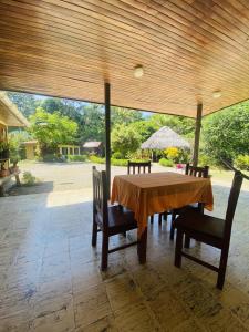 una mesa de madera y sillas en un patio en La Purruja Lodge, en Golfito