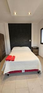 Un dormitorio con una cama grande con almohadas rojas. en La Emilia en Cafayate