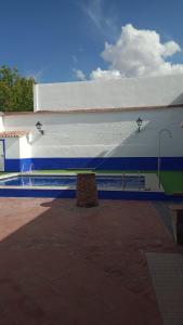 un edificio azul y blanco con un banco al lado en Casa rural el Retiro de Sancho, en Cózar