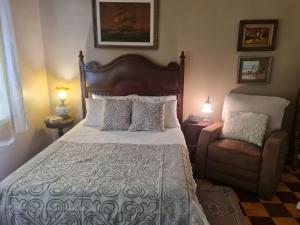 um quarto com uma cama grande e uma cadeira em Charmoso Apartamento Retrô no Hotel Quitandinha com vaga de garagem em Petrópolis