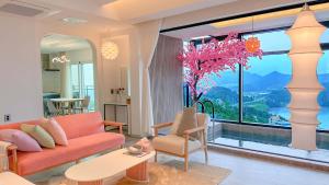 a living room with a couch and a large window at Simer Resort & Pool Villa in Yeosu