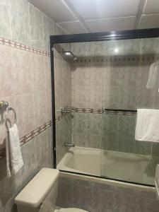 y baño con ducha, aseo y bañera. en Hotel Ensueños, en Cuenca