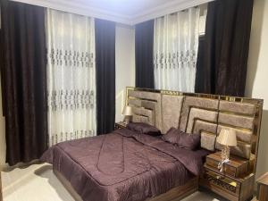 1 dormitorio con 1 cama con sábanas y cortinas moradas en Elegant apartments for rent., en Amán