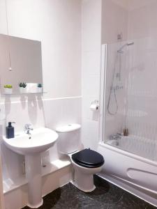 a white bathroom with a toilet and a sink at Kelham Island - City Centre - Stylish - 2 BD - Free On-street Parking - Netflix - Fast WiFi in Sheffield